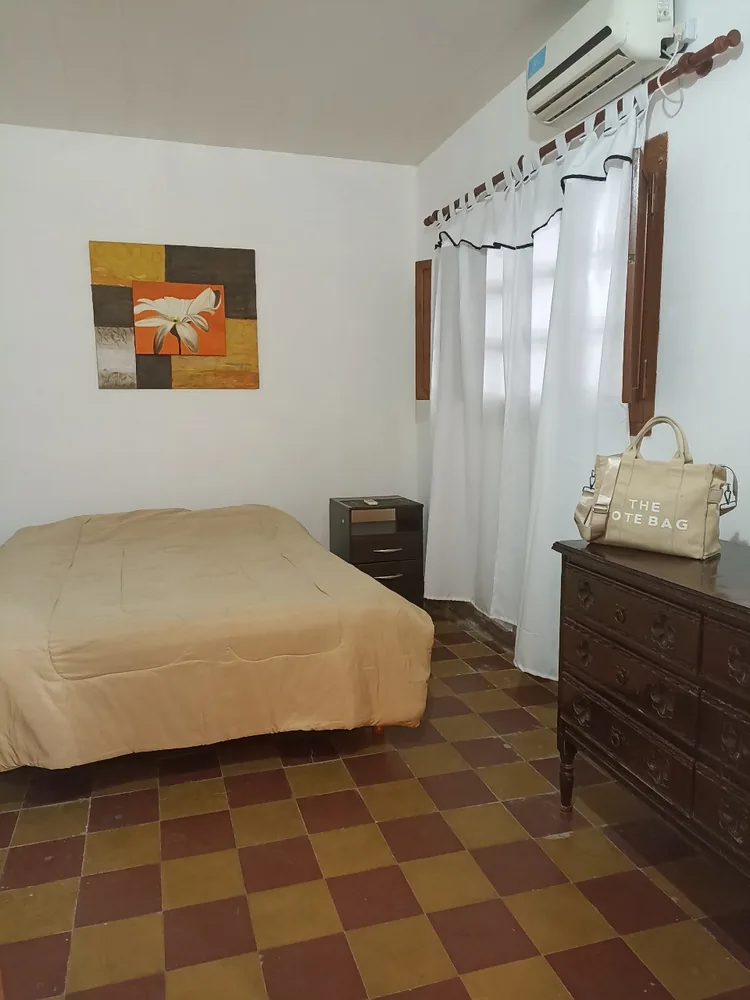 Dormitorio con cama matrimonial, ventana y cómoda.