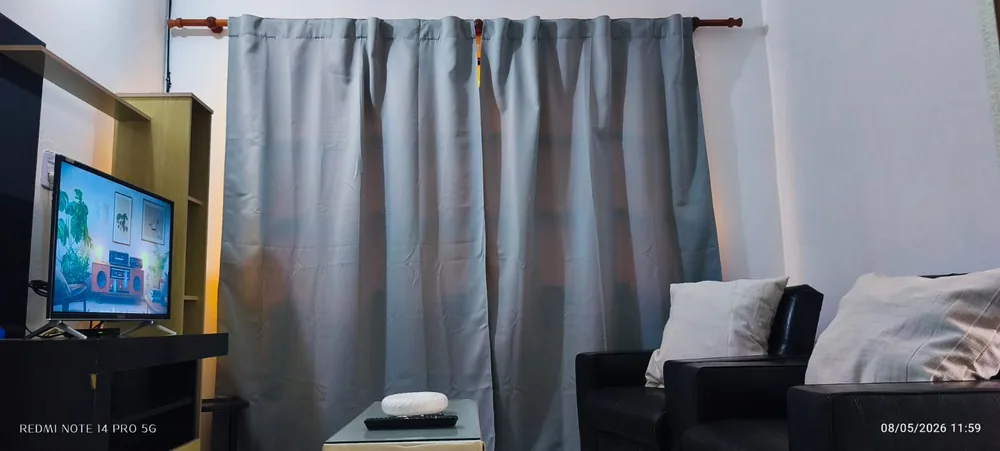 Otro ángulo del living con sillones, mesa baja y televisor.
